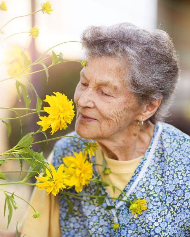 Senior smelling flower valeo memory care neighborhood sarabella florida